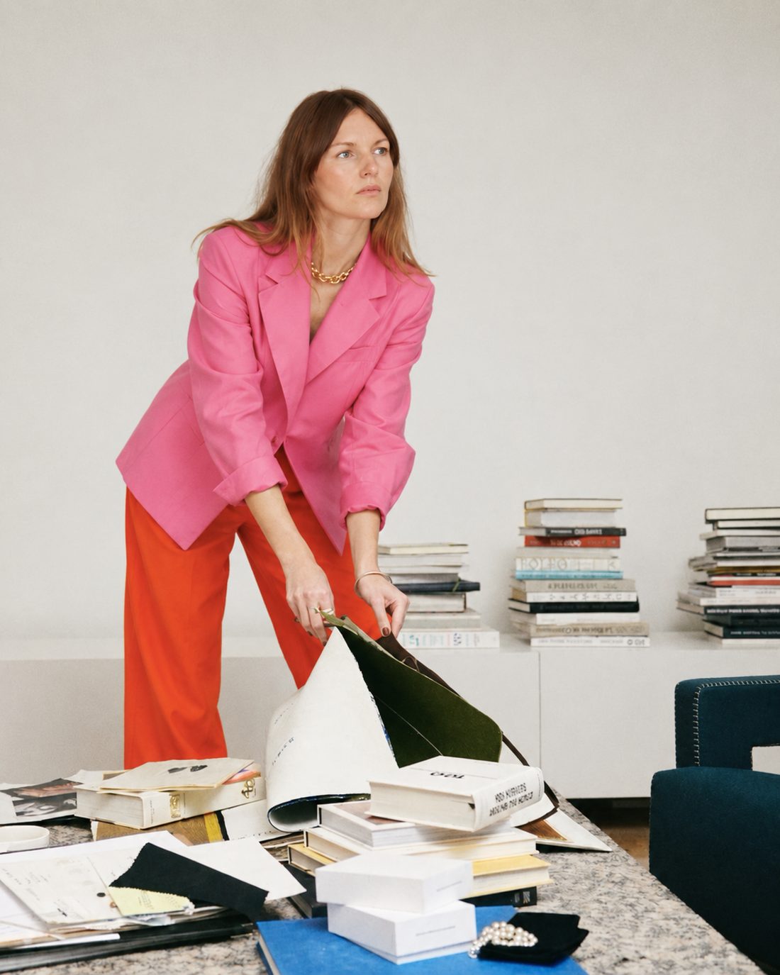Julia Krummhauer sortiert Bücher, Drucke und Materialproben auf einem Tisch